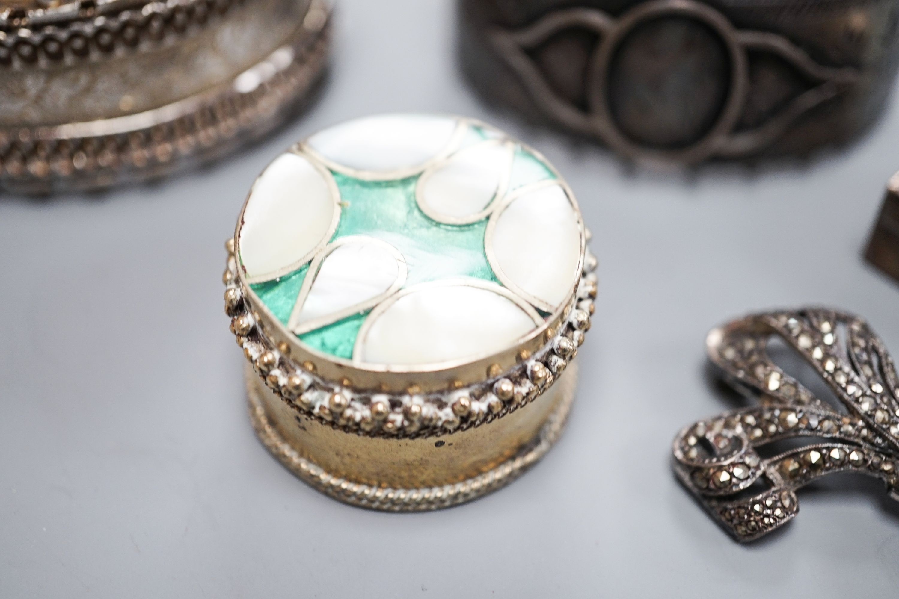 Two white metal bangles including sterling, a marcasite brooch, gem set yellow metal ring and other minor items.